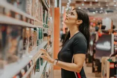 Une cliente choisit un produit dans le rayon d’un magasin.