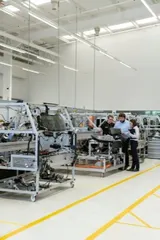 Des techniciens travaillent sur une ligne d’assemblage dans un atelier industriel.