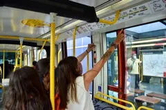 Des voyageuses consultent un plan affiché au-dessus des portes d’un tramway.
